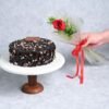 A regal bouquet of fresh roses paired with a delicious cake, the perfect indulgence for any occasion.