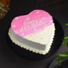 Two‑tier pink and white buttercream cake with rosette piping, pearl accents, and a “Happy Anniversary” topper.