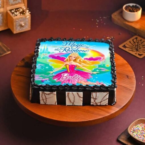 Barbie’s Rainbow Cake featuring a Barbie doll in a multicolored fondant gown with rainbow layers and pastel decorations.