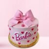 Barbie cake in blush pink with a large fondant bow and elegant dress design—perfect for a stylish birthday celebration.