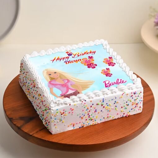 Barbie Dream Cake with a doll topper in a pink and purple frosted gown, surrounded by elegant edible decorations.