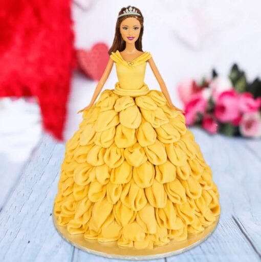 Belle doll cake wearing a golden buttercream ball gown adorned with red fondant roses and shimmering accents.