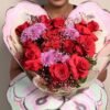 Romantic bouquet of scarlet red roses with soft blush accents.