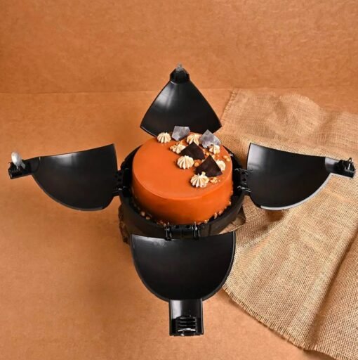 Round caramel chocolate bomb cake with a wooden hammer, hiding caramel treats and candies inside.