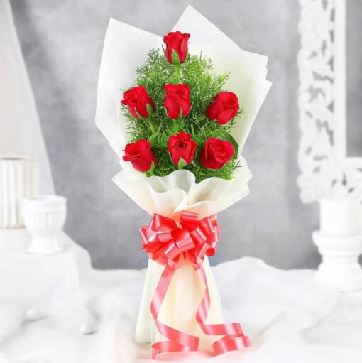 A stunning floral arrangement of deep red roses and elegant mixed blooms wrapped beautifully, symbolizing love and timeless romance.