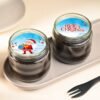 Christmas-themed chocolate jar cake with snowy icing and holiday decorations.