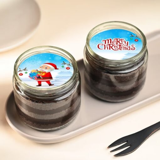 Christmas-themed chocolate jar cake with snowy icing and holiday decorations.