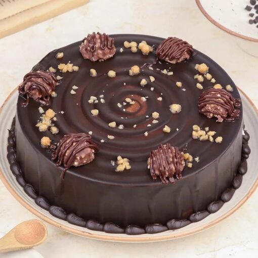 Chocolate truffle cake topped with Ferrero Rocher and chocolate drizzle.