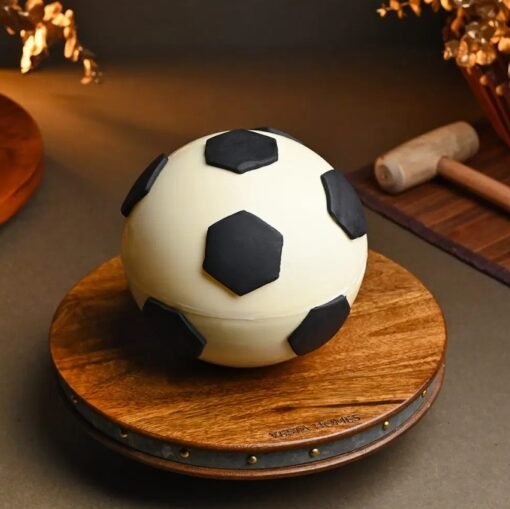 Soccer-themed pinata cake shaped like a football with hidden candies and chocolates inside.