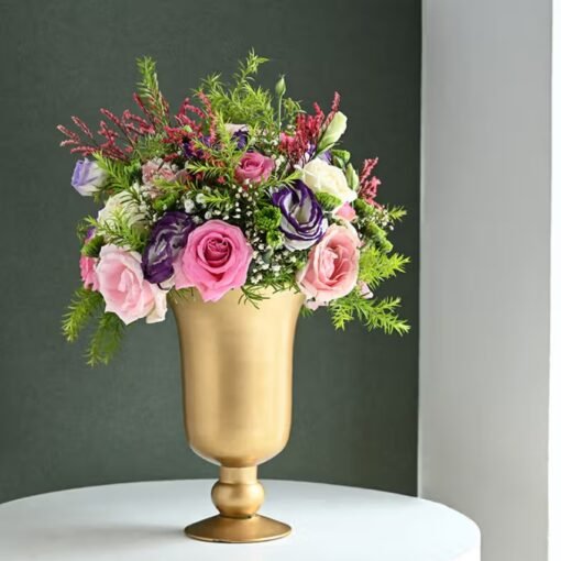 Golden vase filled with a vibrant mix of fresh, opulent flowers.