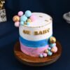Gender reveal cake with “Oh Baby!” topper and hidden pink or blue filling inside.