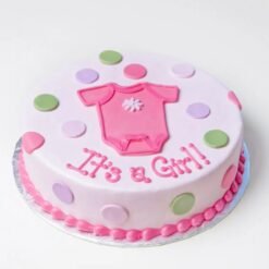 It’s A Girl themed cake with pink decorations, baby toppers, and soft pastel design.