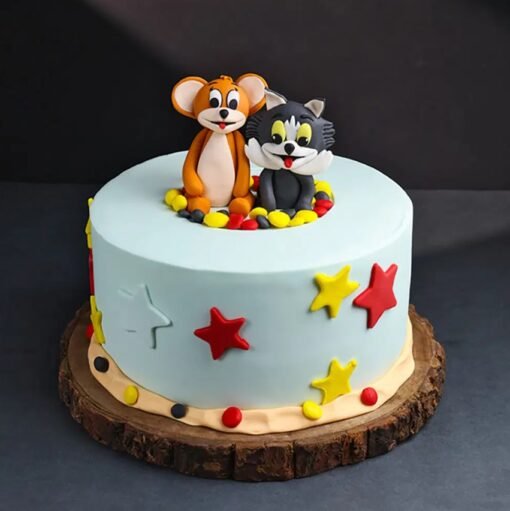 Tom and Jerry-themed cake with fondant figures of the cat and mouse duo, cartoon elements, and colorful birthday decorations.