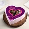 Heart-shaped photo cake with Valentine’s Day decorations and personalized image on top.