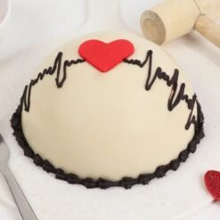 Heart-shaped heartbeat pinata cake with red accents and hidden treats inside.