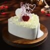 Heart-shaped creamy cake decorated with pearl-like accents, ideal for weddings, anniversaries, and romantic celebrations.