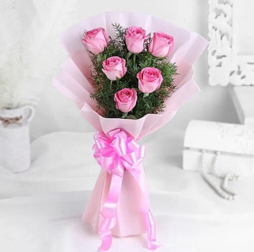 Bouquet of fresh light pink roses wrapped in soft pastel packaging, symbolizing love, sweetness, and grace.