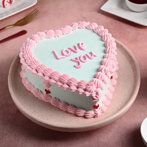 Heart-shaped vintage-style cake with pastel frosting, lace piping, and elegant floral decorations.