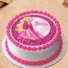 Pretty In Pink Barbie Cake decorated with pink ruffles, fondant hearts, and a Barbie doll topper in a flowing pink gown.