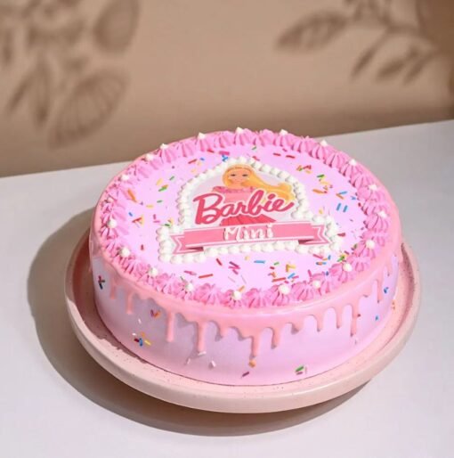 Pink Sprinkled Barbie Cake with a Barbie doll topper, pink frosting, and colorful sprinkles.