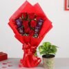 A vibrant floral arrangement paired with sweet treats, and money plant perfect for gifting.