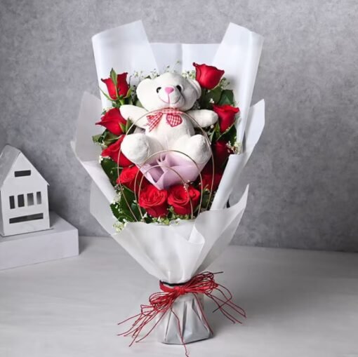 Bouquet of blooming fresh flowers with a soft teddy bear, perfect for romantic gifting.