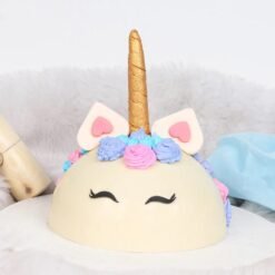 Unicorn-themed smash cake with colorful decorations and hidden treats inside.