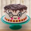 Harry Potter-themed face cake with signature glasses, lightning scar, and Hogwarts-inspired decorations.
