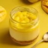 Silky Mango Jar Cheesecake with creamy mango layers and biscuit base in a clear jar.