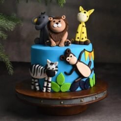 Happy Animals Jungle Cake with fondant jungle animals and green foliage decorations.