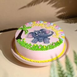 Pink baby elephant-themed cake with fondant decorations for baby girl