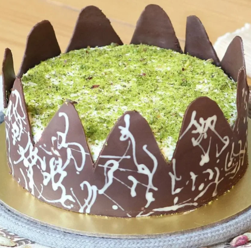 Rich chocolate cake topped with pistachio drizzle and crunchy nuts