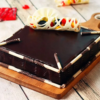 Chocolate truffle cake topped with fresh fruits and glossy glaze