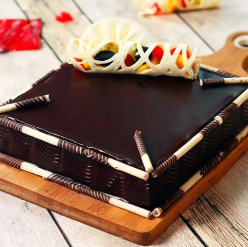 Chocolate truffle cake topped with fresh fruits and glossy glaze