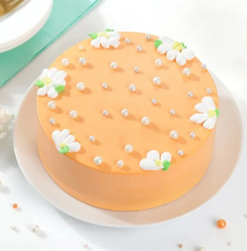 Peach-colored floral cake with elegant cream design
